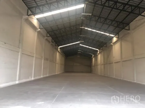 货栈 出租在Pathum Thani - 仓库内部空旷，高钢结构屋顶带采光带，混凝土地面平整。