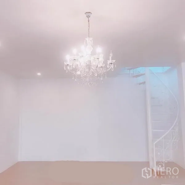 带办公室的家 出租或出售在Phra Khanong, Bangkok - 极简房间，水晶吊灯与通往二层的弧形楼梯。