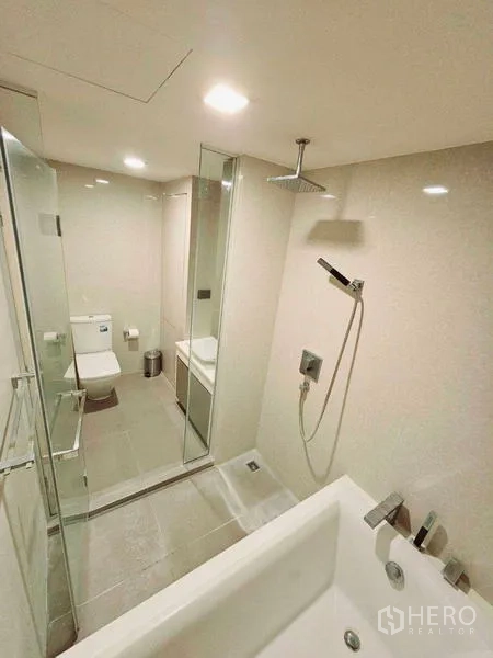 Condominium for rent - Modern bathroom featuring glass shower, bathtub and rain shower head.