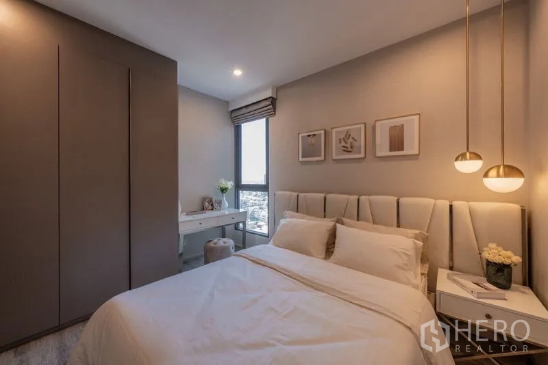 Condominium for rent in Bang Na, Bangkok - Second bedroom with pendant lights, padded headboard, window desk and fitted wardrobe.