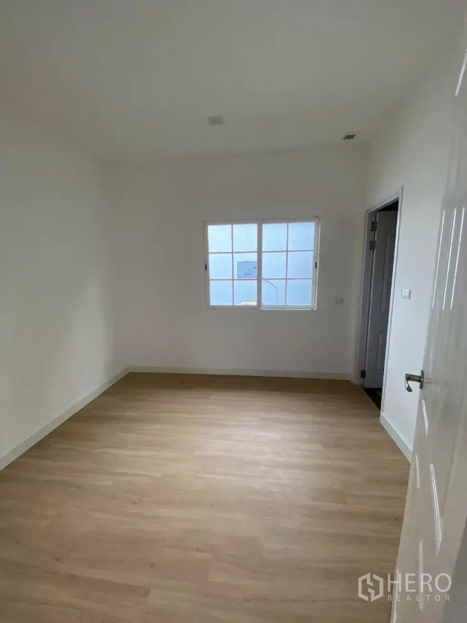 Detached House for rent in Bang Phli, Samut Prakan - Ground-floor multipurpose room with wood-look flooring and adjacent bathroom door.