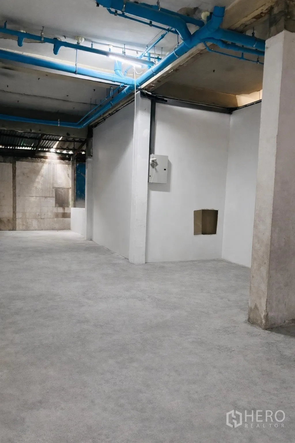 พื้นที่ขายของ for rent in Watthana, Bangkok - พื้นที่ค้าปลีกแบบเปิดลึก มีผนังกั้นสีขาว พื้นคอนกรีต และงานระบบบนเพดาน.