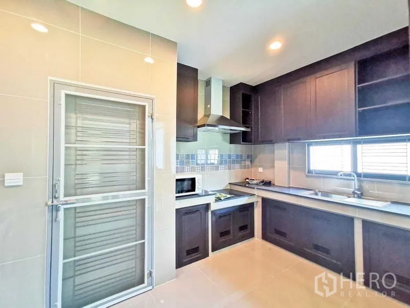 บ้าน ให้เช่าหรือขายในPrawet, Bangkok - ครัวรูปตัวแอล โทนไม้เข้ม มีตู้บิวท์อิน เครื่องดูดควัน และหน้าต่าง