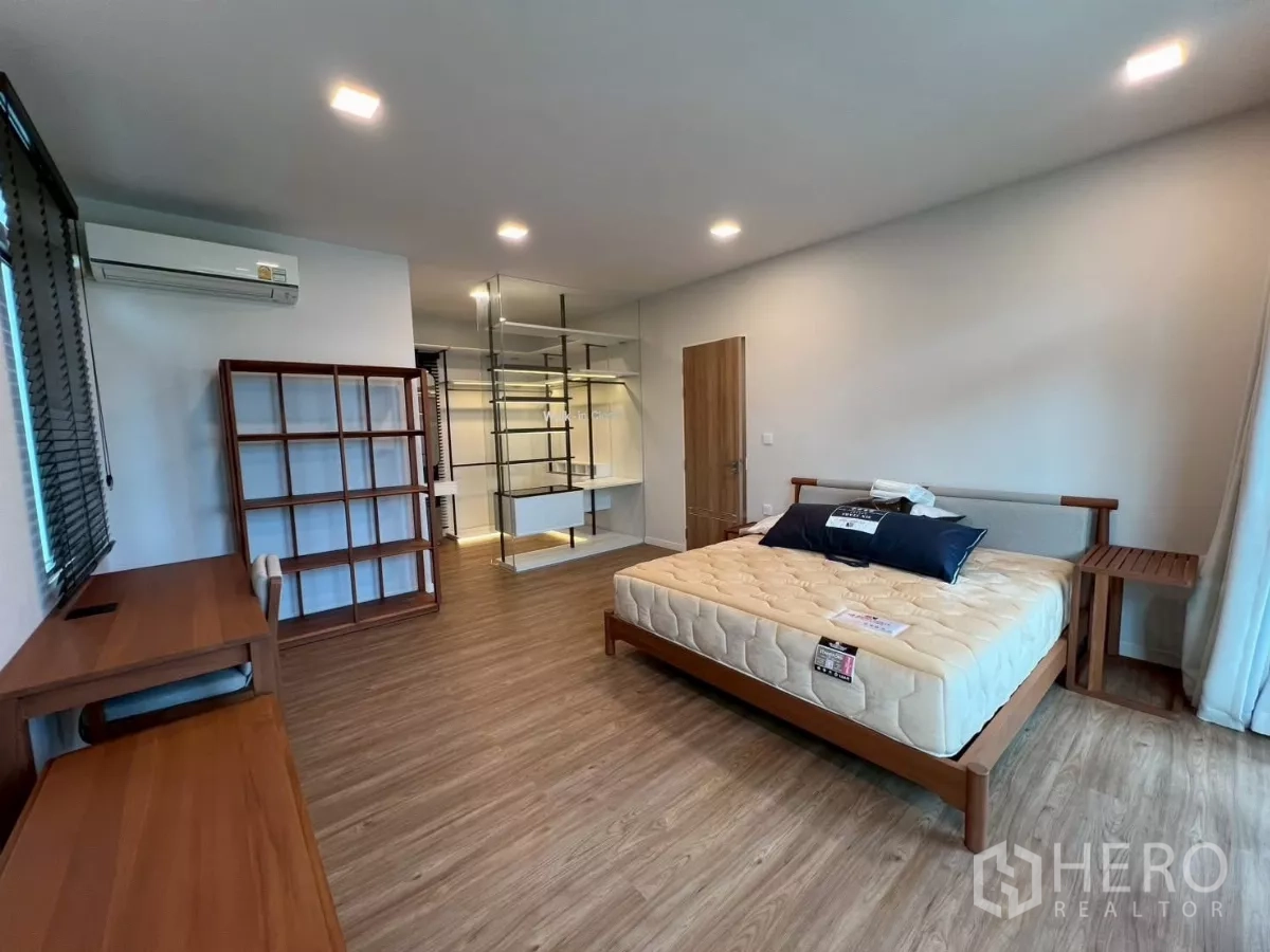 Detached House for rent in Samut Prakan - Large master bedroom with bed, study desk, and glass walk-in closet.