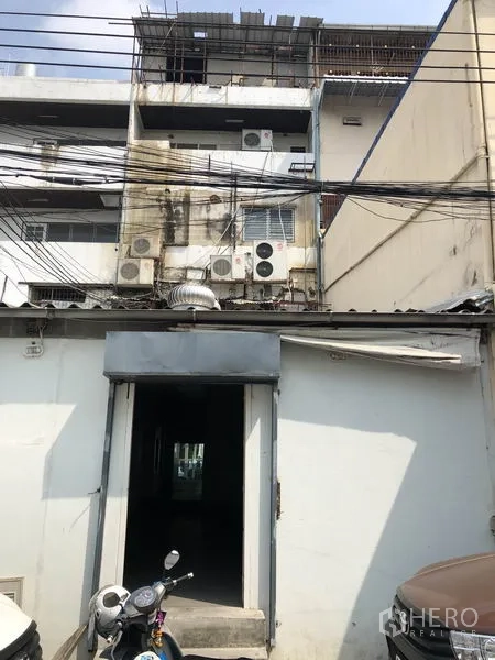 สำนักงานที่บ้าน ให้เช่าหรือขายในHuai Khwang, Bangkok - ด้านหลังอาคารมีทางเข้าเซอร์วิส คอมเพรสเซอร์แอร์หลายตัว และสายไฟเหนือศีรษะ