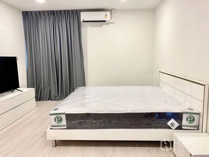คอนโด ให้เช่า - ห้องนอนหลักสไตล์มินิมอล เตียงคิงไซส์ แอร์ ทีวี และผ้าม่านทึบ