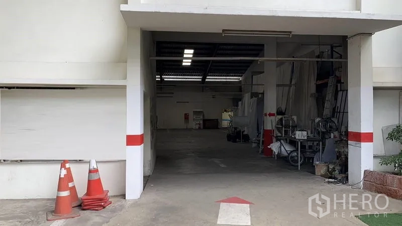 Warehouse for rent in Phra Pradaeng, Samut Prakan - Covered drive-through entrance leading to the warehouse work area.