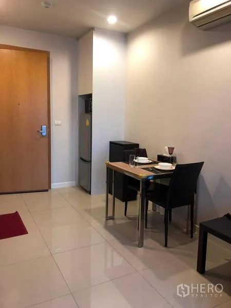 Condominium for sale in Ratchathewi, Bangkok - Entry corridor with a two-seat dining table, refrigerator alcove and tiled flooring.