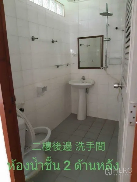 Townhouse for rent in Watthana, Bangkok - Compact white‑tiled bathroom with shower, pedestal sink and toilet.