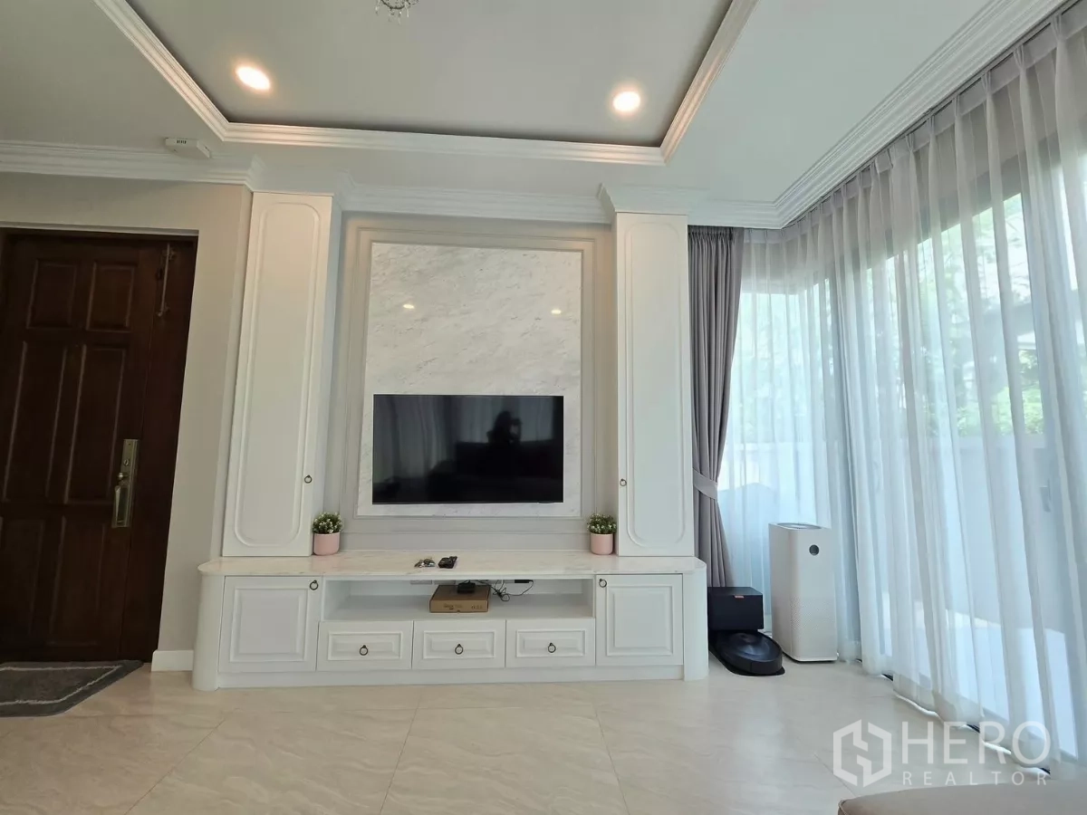 Detached House for rent in Prawet, Bangkok - Built‑in media wall with mounted TV, recessed lights and full‑height curtains.