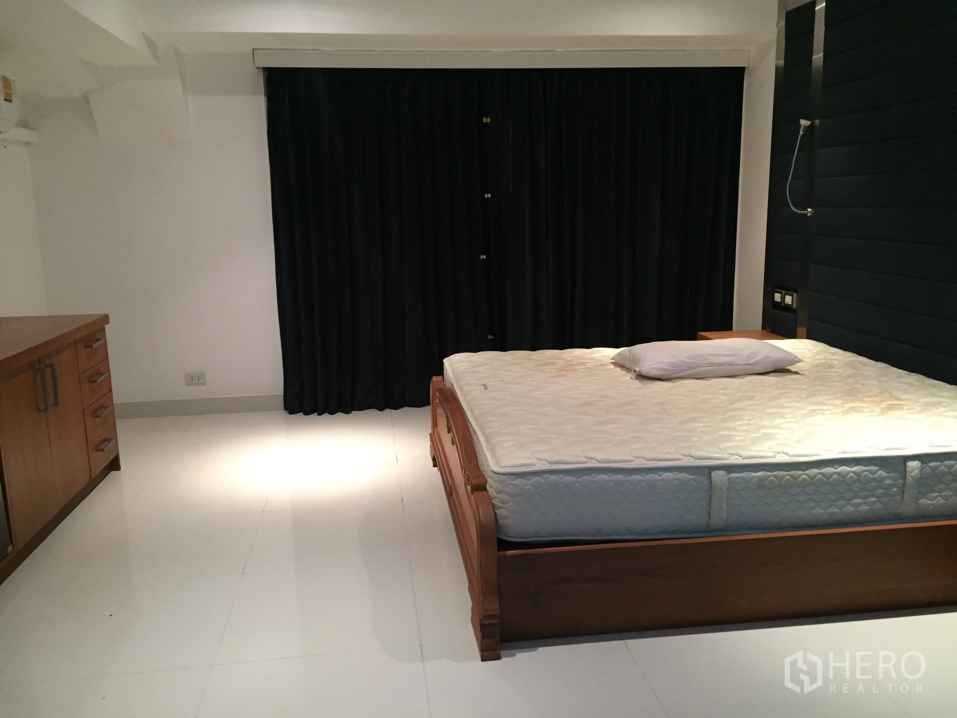 公寓 出租在Khlong Toei, Bangkok - 主卧配木床，白色地砖与遮光窗帘