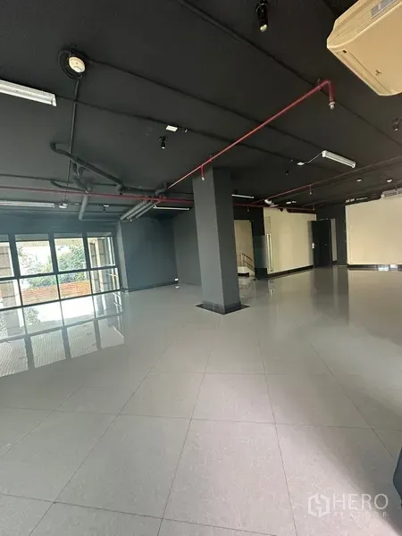 办公空间 出租在Khlong Toei, Bangkok - 宽敞办公室，黑色外露顶与瓷砖地面，多处玻璃门。