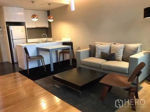 คอนโด ให้เช่าในWatthana, Bangkok - ห้องนั่งเล่นโมเดิร์น โซฟา ชุดทานข้าว และเคาน์เตอร์ครัวสีขาวพร้อมโคมไฟแขวน