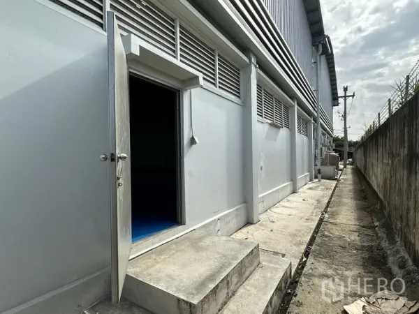 โรงงาน ให้เช่าในKhlong Luang, Pathum Thani - ทางเข้าบริการด้านข้างของโรงงาน มีบานเกล็ดระบายอากาศและทางเดินคอนกรีตขนาบกำแพง