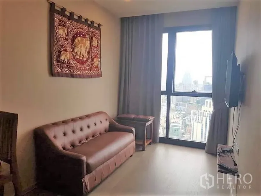 คอนโด ให้เช่าในWatthana, Bangkok - ห้องนั่งเล่นพร้อมทีวีติดผนัง โซฟา และหน้าต่างสูงเต็มบานวิวเมือง