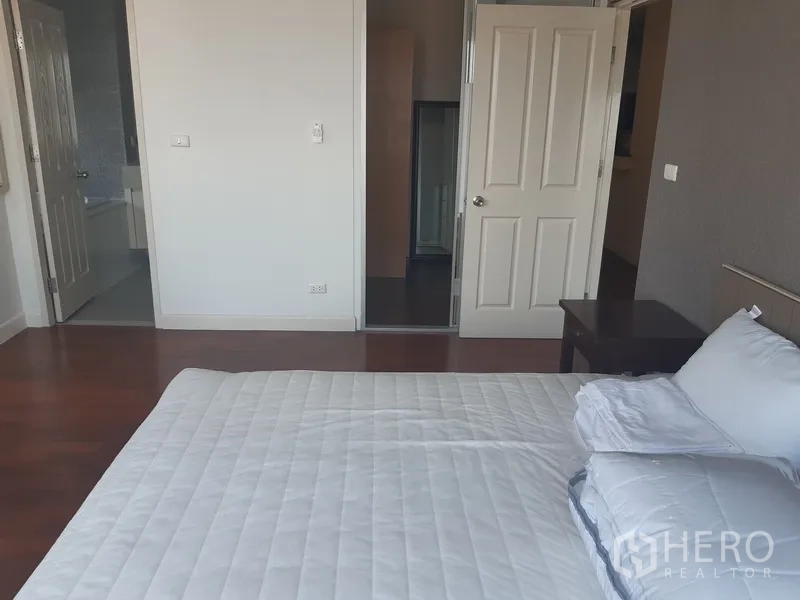 คอนโด ให้เช่าในKhlong Toei, Bangkok - ห้องนอนมาสเตอร์มองไปยังโถงและทางเข้าห้องน้ำ พื้นไม้สวยงาม