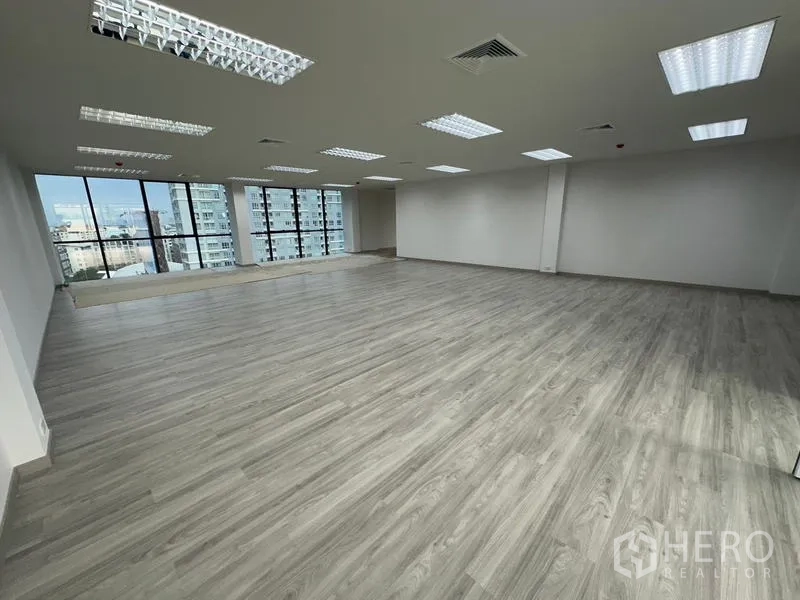 สำนักงาน ให้เช่า - พื้นที่สำนักงานกว้างโล่ง พื้นลายไม้ ไฟ LED และผนังกระจกมองเห็นตึกโดยรอบ