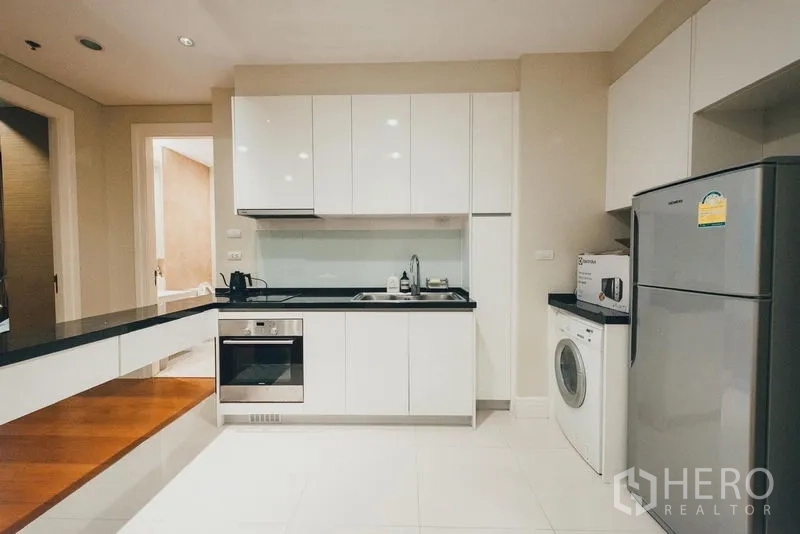 คอนโด ให้เช่าในKhlong Toei, Bangkok - ครัวยุโรปสีขาว ท็อปหิน เตาอบ ตู้เย็น และเครื่องซักผ้า