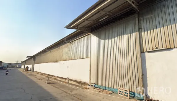 คลังสินค้า ให้เช่าในBang Sao Thong, Samut Prakan - มุมมองภายนอกโกดังผนังเมทัลชีต พร้อมถนนคอนกรีตกว้าง รองรับรถบรรทุกตู้คอนเทนเนอร์