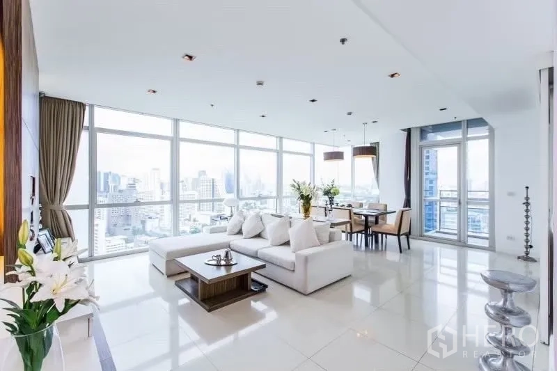Condominium for rent in Pathum Wan, Bangkok - Bright open-plan living and dining room with floor-to-ceiling windows and Bangkok skyline views.