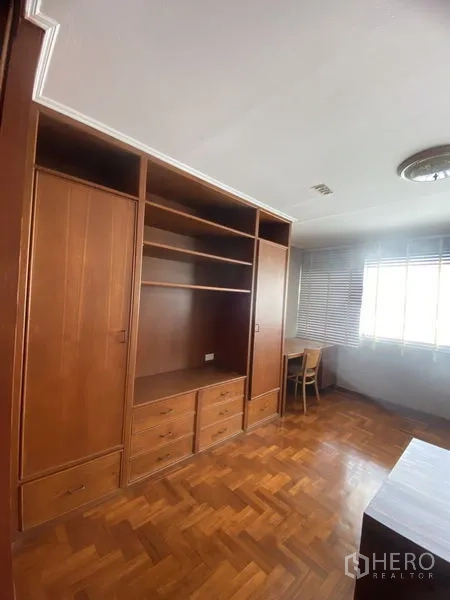 公寓 出租在Sathon, Bangkok - 第三卧室设嵌入式书柜衣柜，窗边书桌与木地板。