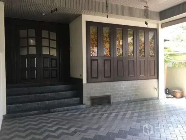 联排别墅 出租在Khlong Toei, Bangkok - 有顶入口与车位，台阶通向深色木双开门