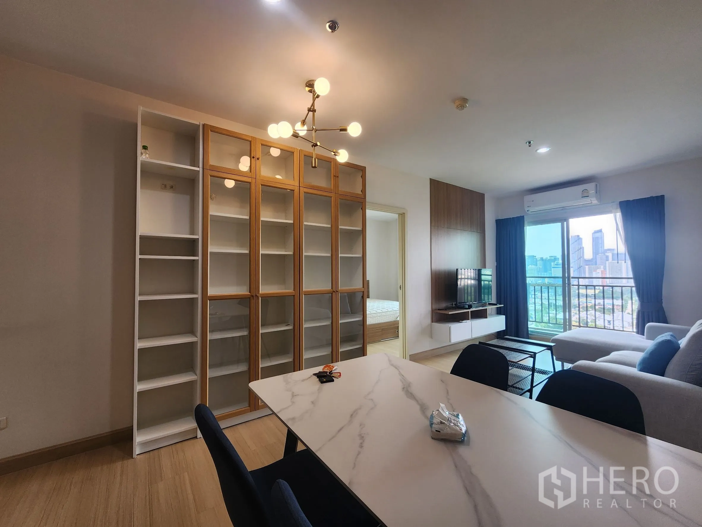 คอนโด for rent in Huai Khwang, Bangkok - พื้นที่เปิดโล่งนั่งเล่น–รับประทานอาหาร ผนังตู้บิวท์อิน โคมไฟ และวิวระเบียง