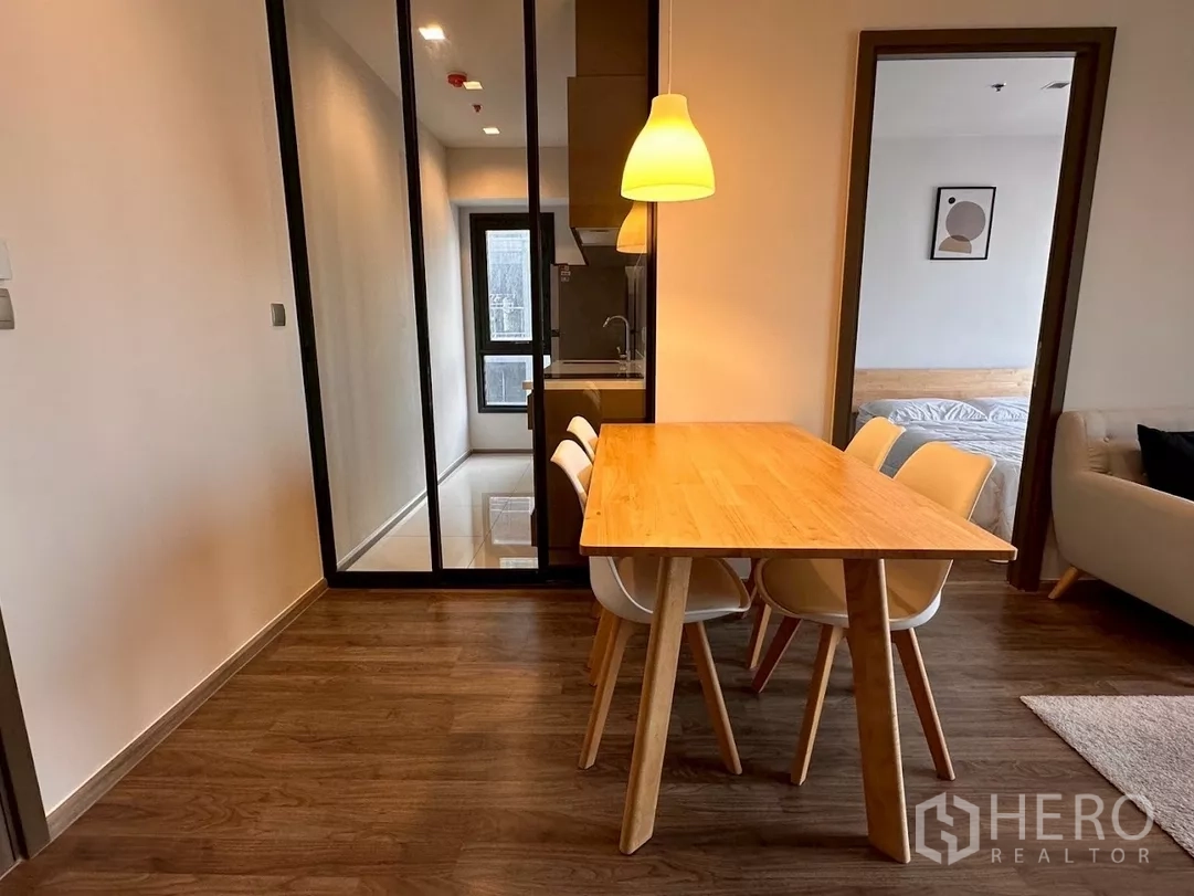 Condominium for rent in Chatuchak, Bangkok - Dining table centered between kitchen entrance and bedroom doorway.