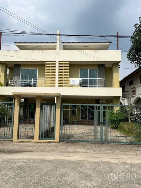 联排别墅 出租在Bang Kapi, Bangkok - 曼谷两层联排别墅外观，带围栏大门与前院车位