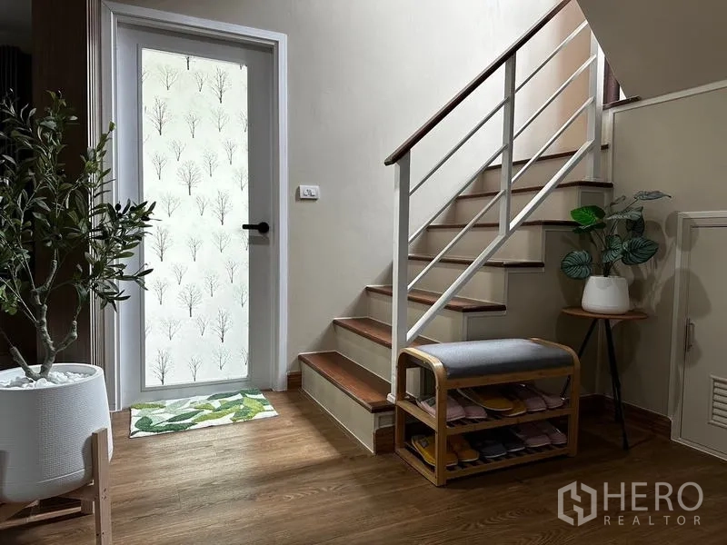 独立式住宅 出租在Prawet, Bangkok - 入户楼梯间，木阶、鞋架与磨砂玻璃门。