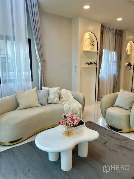 Detached House for rent in Bang Phli, Samut Prakan - Elegant living room with curved sofas, sheer curtains and a sculpted white coffee table.