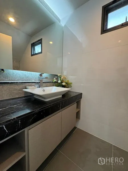 Detached House for rent in Prawet, Bangkok - Bathroom with stone countertop, vessel sink and large mirror.
