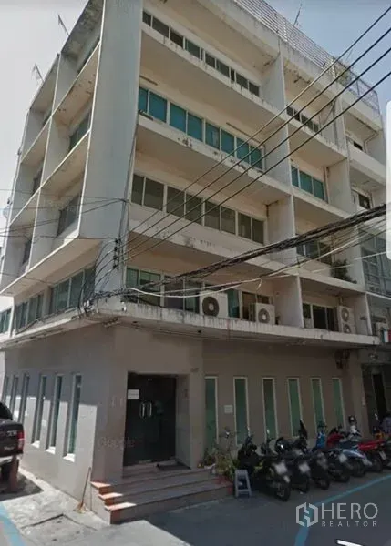 Office Space for rent in Khlong Toei, Bangkok - Street-level view of a low-rise office building with balconies and parked motorbikes.