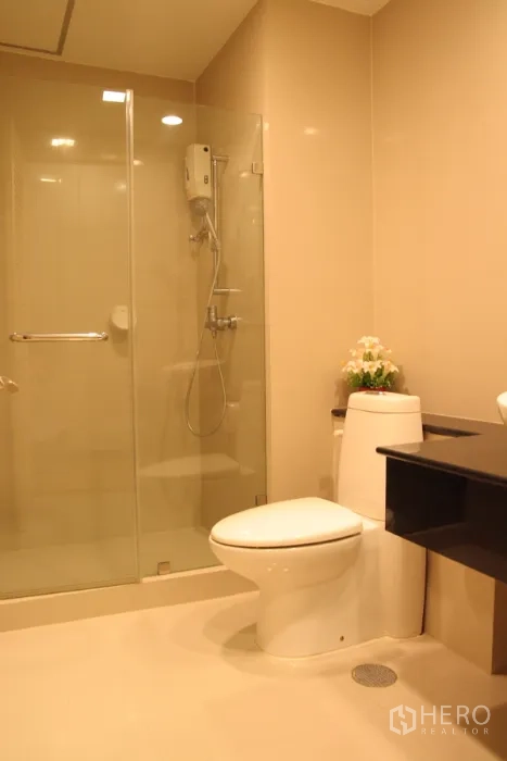 คอนโด ให้เช่าในKhlong Toei, Bangkok - ห้องน้ำสไตล์โมเดิร์น พร้อมตู้ฝักบัวกระจกและโถสุขภัณฑ์ โทนสีอบอุ่น