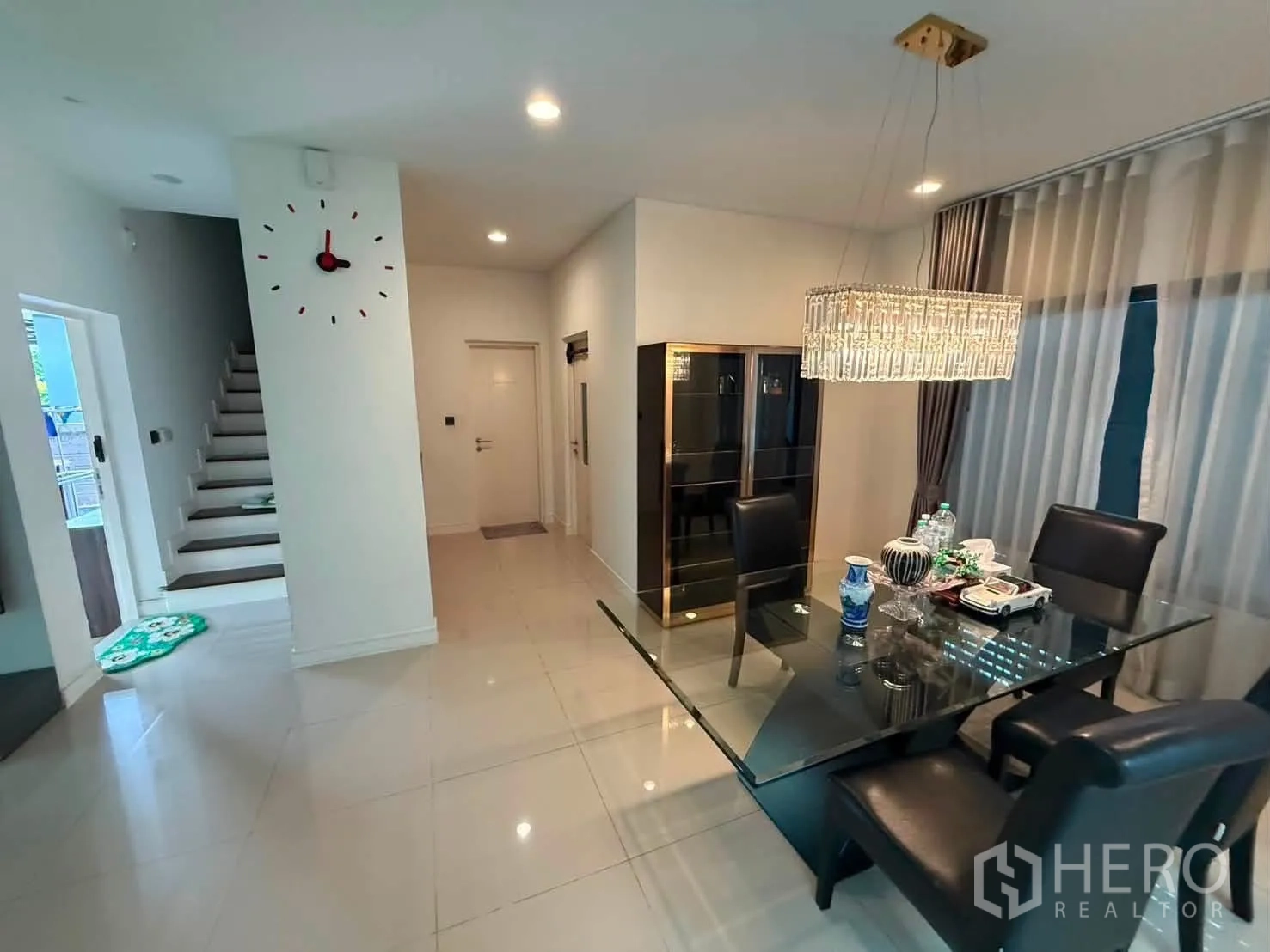 独栋房屋 for rent in Bang Kapi, Bangkok - 餐区设玻璃餐桌、皮质餐椅与水晶吊灯。