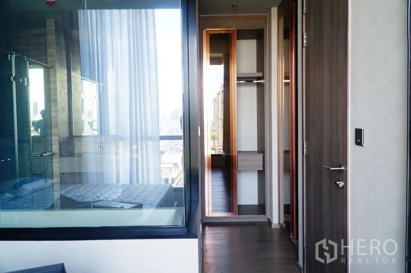 公寓 出租在Watthana, Bangkok - 通往步入式衣帽间的过道，浴室与卧室以玻璃隔断。