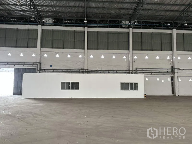 工厂 出租在Bang Bua Thong, Nonthaburi - 仓库内的办公室模块，配窗户与白墙。