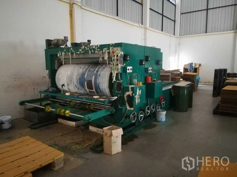 Factory for sale in Bang Len, Nakhon Pathom - Green processing machine with rollers and control panel in the warehouse.