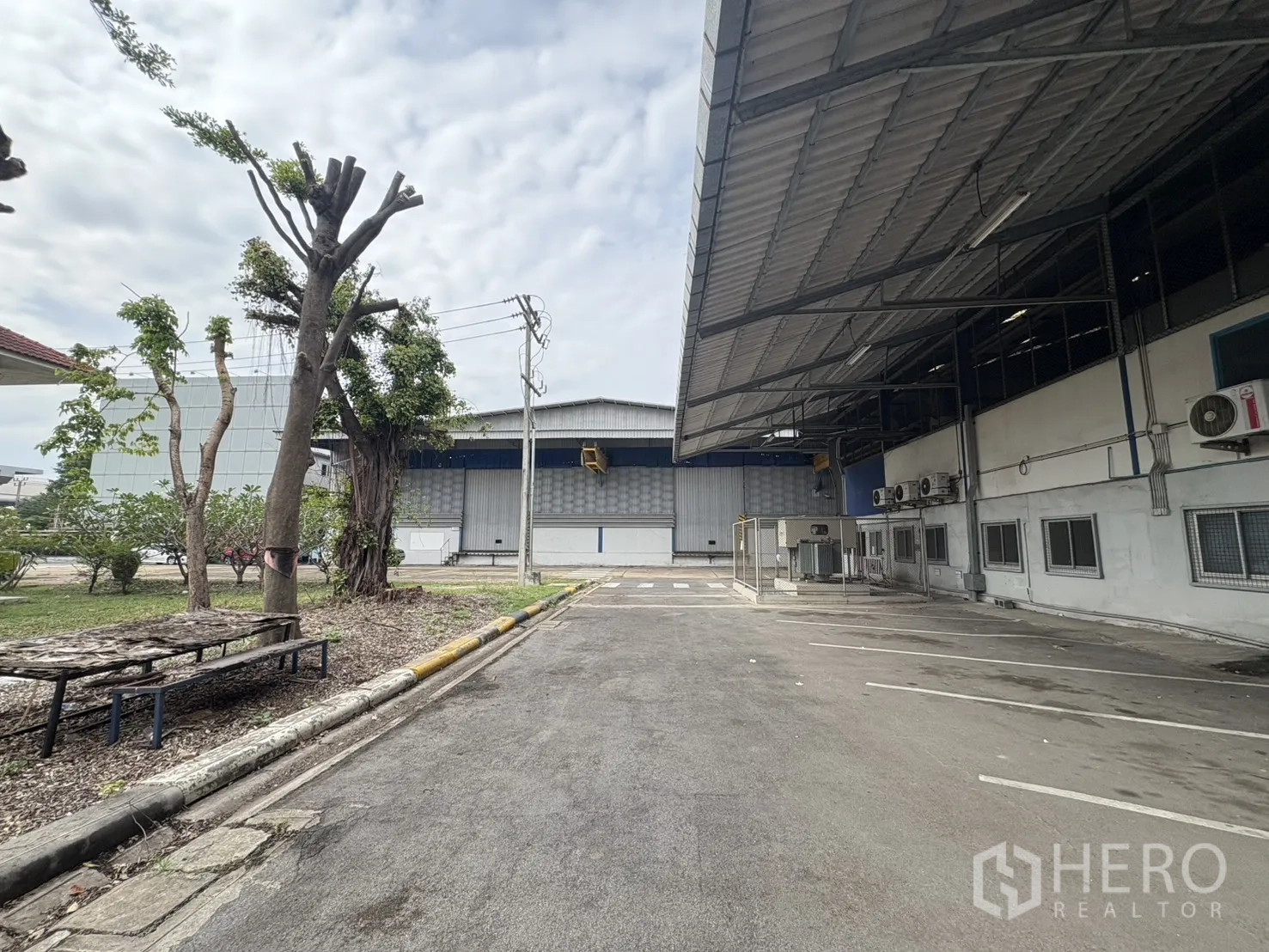 工厂 出租在Phra Pradaeng, Samut Prakan - 仓库侧边有顶通道与绿化带。