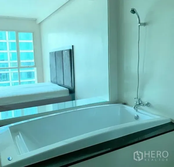 คอนโด ให้เช่าในPathum Wan, Bangkok - ห้องน้ำพร้อมอ่างอาบน้ำ มีกระจกมองไปยังห้องนอน เห็นวิวตึกสูง