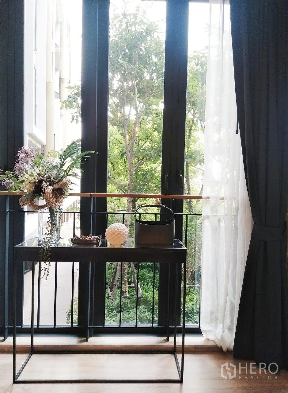 公寓 for rent in Watthana, Bangkok - 落地窗前的玄关桌，眺望郁郁葱葱的树景。