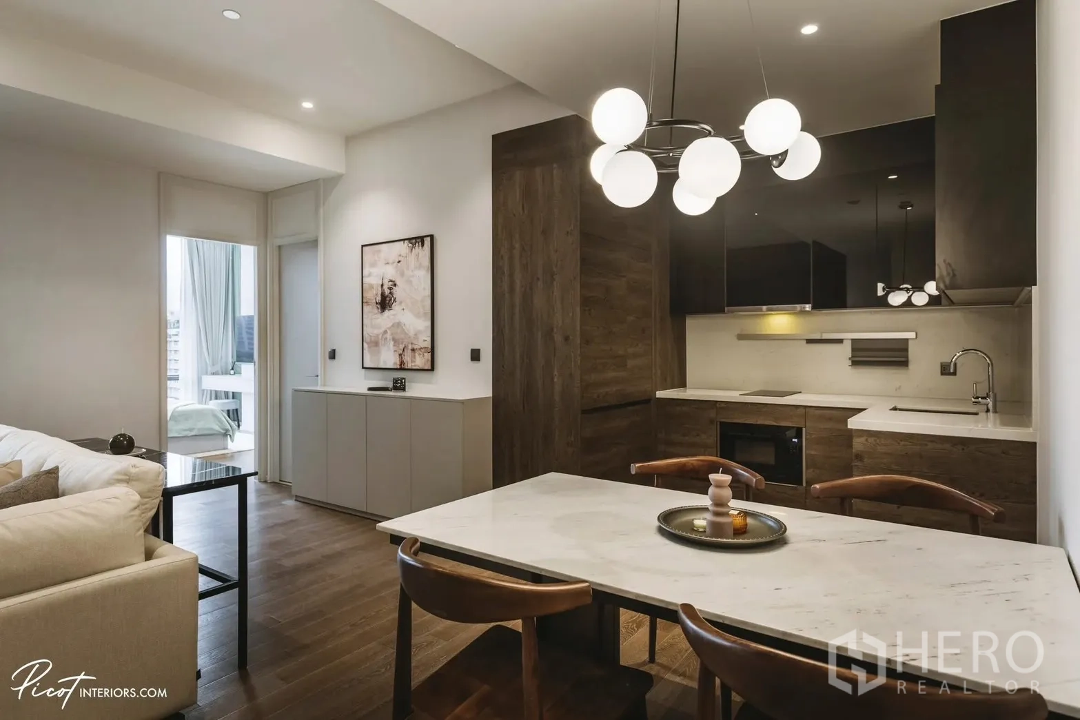 Condominium for rent in Pathum Wan, Bangkok - Dining area beside a contemporary kitchen with built-in oven and cabinetry.