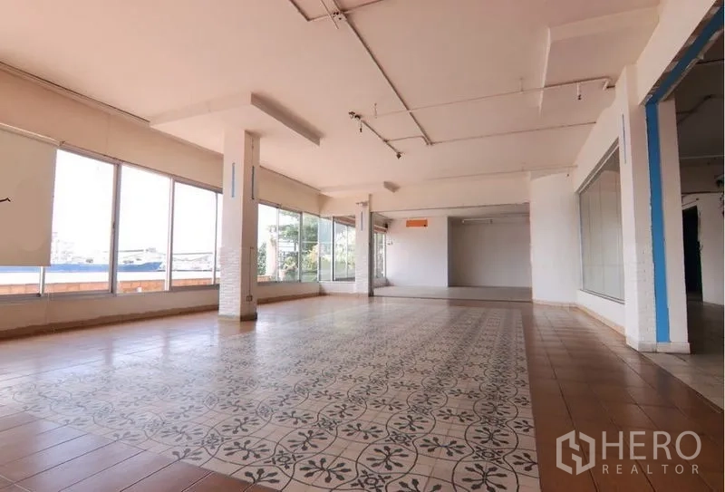 零售空间 出租在Yan Nawa, Bangkok - 明亮展厅，中央花纹地砖与环幕式玻璃窗。