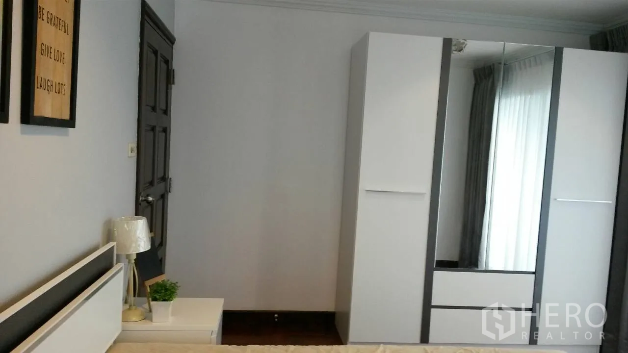 คอนโด ให้เช่าหรือขายในWatthana, Bangkok - ห้องนอนรองพร้อมตู้เสื้อผ้าสีขาวและโต๊ะข้างเตียง