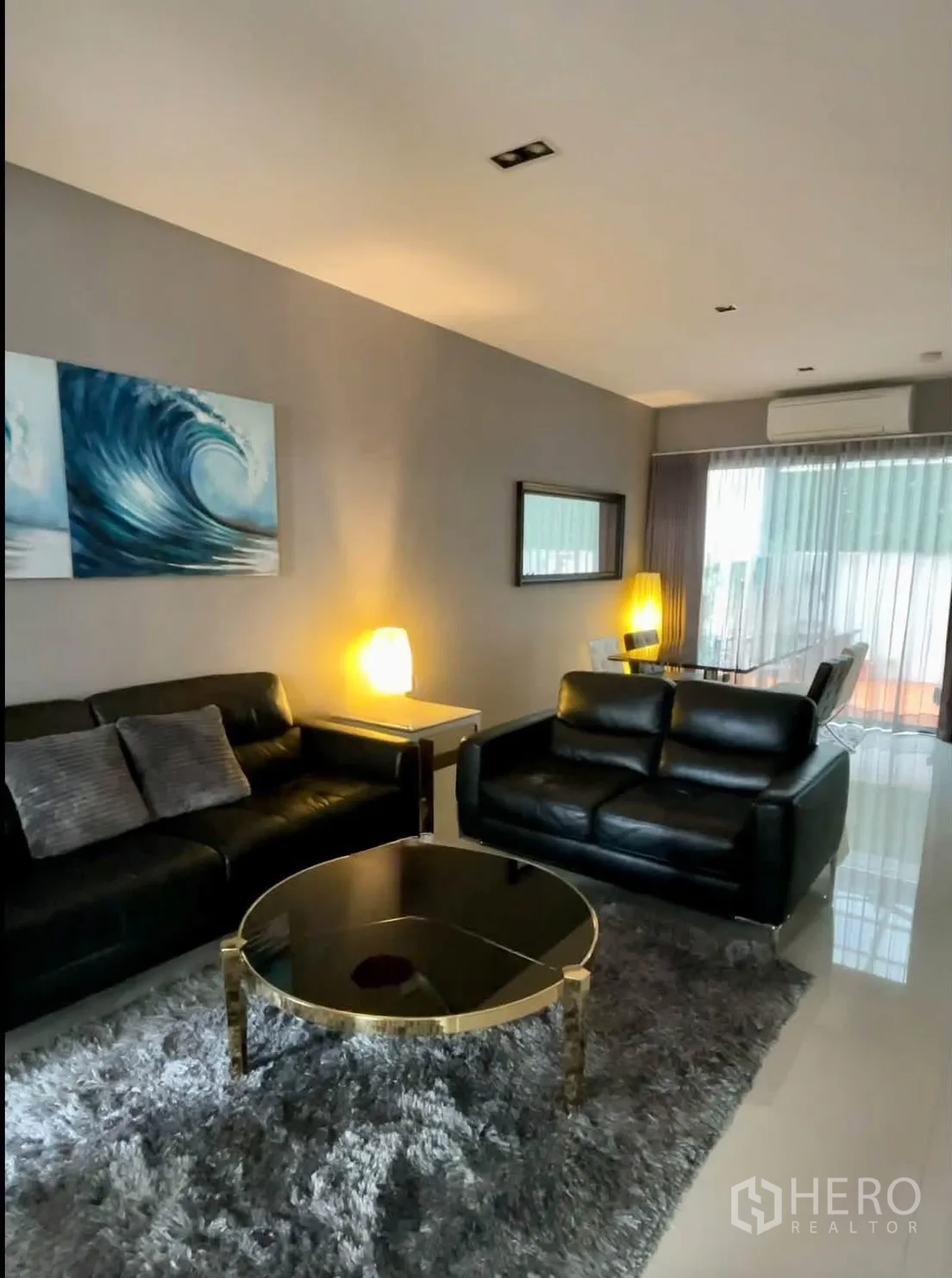 Townhouse for rent in Lat Phrao, Bangkok - Living room with black leather sofas, rug and coffee table.