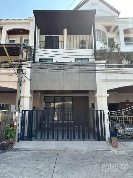 Townhouse for rent in Yan Nawa, Bangkok - Three-storey townhouse exterior with gated carport and balcony.