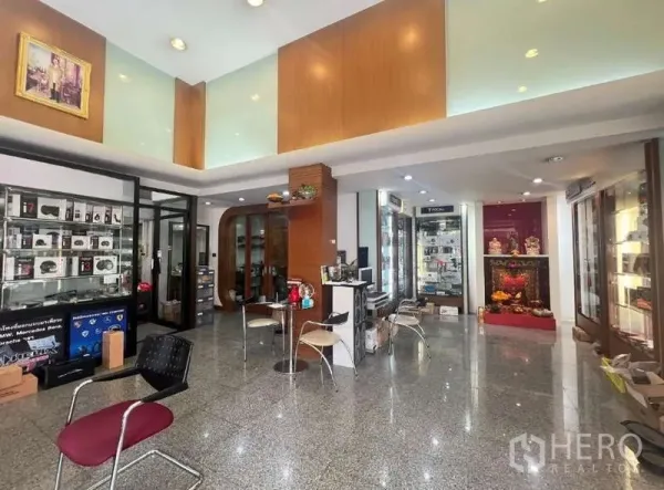 店屋 出租 - 明亮的一层展厅，玻璃展示柜、座椅与抛光石材地面。