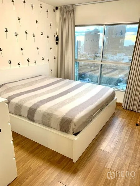 คอนโด ให้เช่าในBang Na, Bangkok - ห้องนอนเตียงผ้าปูลายทาง ผนังวอลเปเปอร์ และหน้าต่างกว้างเห็นวิวเมือง