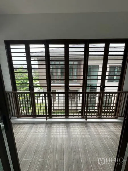 Detached House for rent in Bang Kapi, Bangkok - Covered balcony featuring louvered wooden panels and tile flooring.