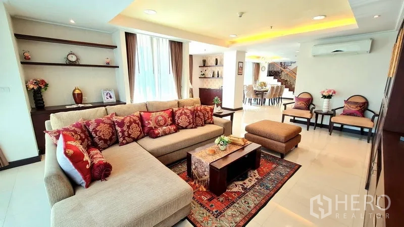 อพาร์ทเมนท์ ให้เช่าในWatthana, Bangkok - ห้องนั่งเล่นสว่าง โซฟาเข้ามุม หมอนลาย พรม และชั้นบิลท์อิน ในอพาร์ตเมนต์ย่านวัฒนา